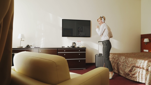 Happy Businesswoman Dancing and Singing While Listening Music on Wireless Headphones While Have Fun alt