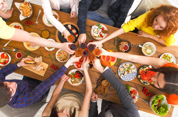 People say cheers clink glasses at festive table dinner party - Stock Photo - Images