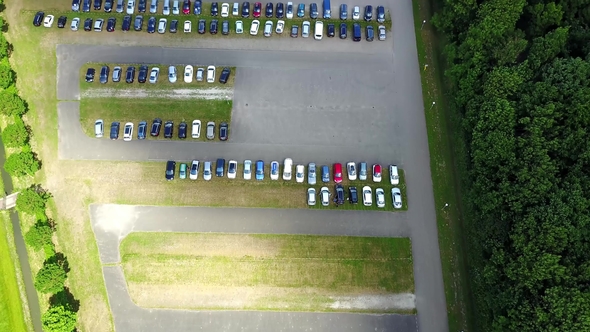 Aerial View of a Huge Car Parking Lot Panning from the Single Car To Many and Back  alt