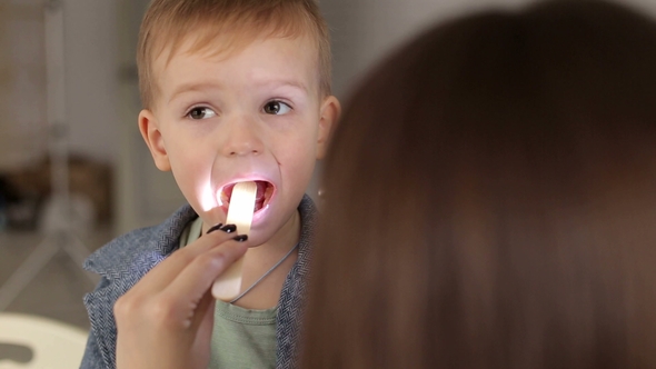 Doctor Examining Child's Throat and Mouth alt