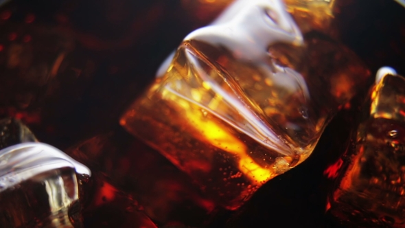 Ice Cubes in a Glass of Cola with Rising Bubbles