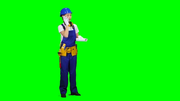 Builder Is Standing and Talking on the Phone with a Drawing in Her Hands alt