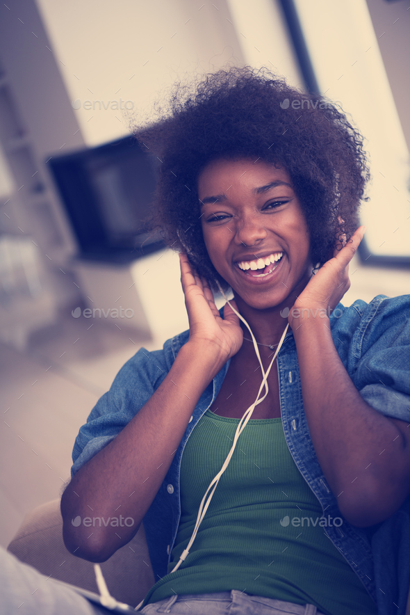 African american woman at home in chair with tablet and head pho - Stock Photo - Images