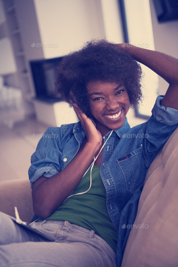 African american woman at home in chair with tablet and head pho - Stock Photo - Images