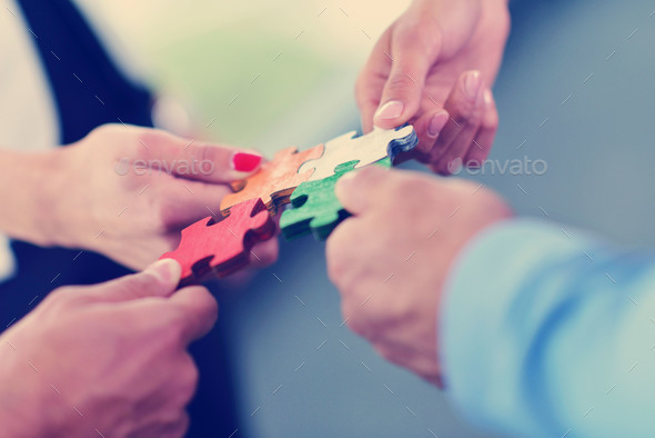 Group of business people assembling jigsaw puzzle Stock Photo by dotshock