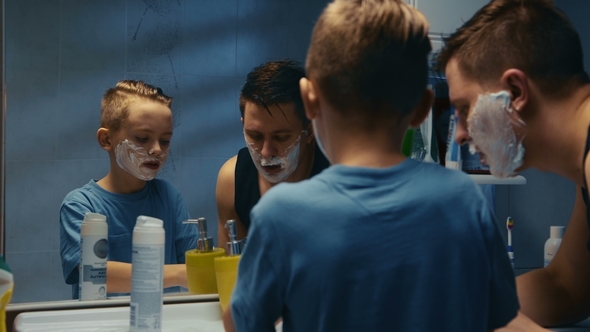 Young Boy Learning to Shave Helped by His Father alt