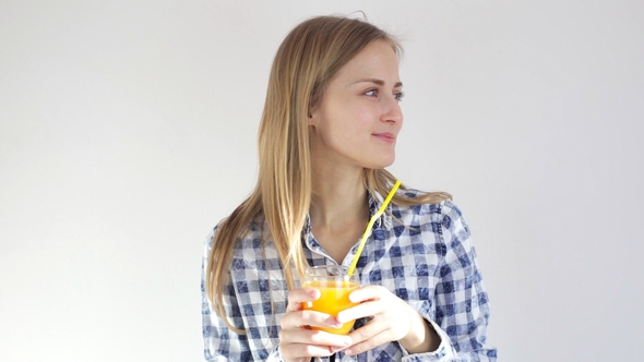 Girl Smiles and Drinks Orange Juice Through a Straw