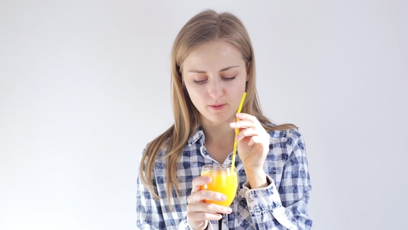 Young Girl Drinks Orange Juice Through a Straw