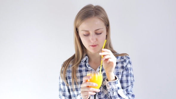 Young Girl Drinks Orange Juice Through a Straw