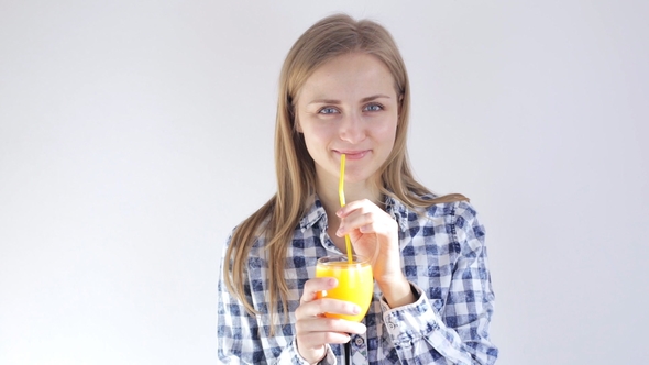 Beautiful Girl Drinks Freshly Squeezed Orange Juice Through a Straw