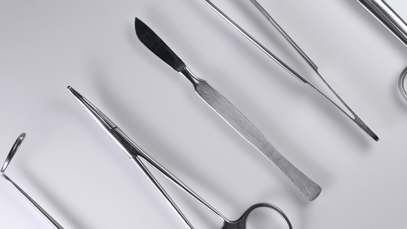 Doctor Takes a Scalpel From the Table with Surgical Instruments, alt