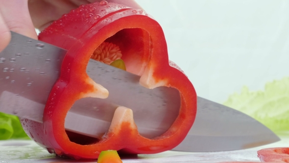 Knife Cuts the Red Pepper. A Large Red Sweet Pepper Is Cut on a Cutting Board alt