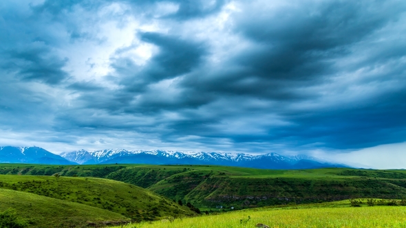 TimeLaps. Dark Thunderclouds Move Quickly Over the Mountains and Fields in the Spring alt