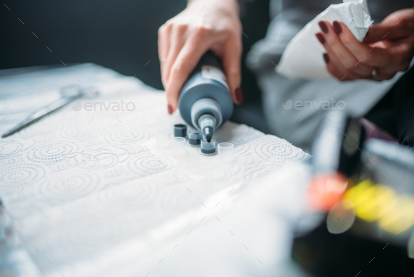 Female tattooist hands holds tattoo machine - Stock Photo - Images
