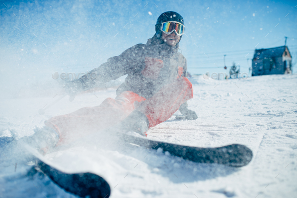 Skier lies on snowy surface of speed slope - Stock Photo - Images