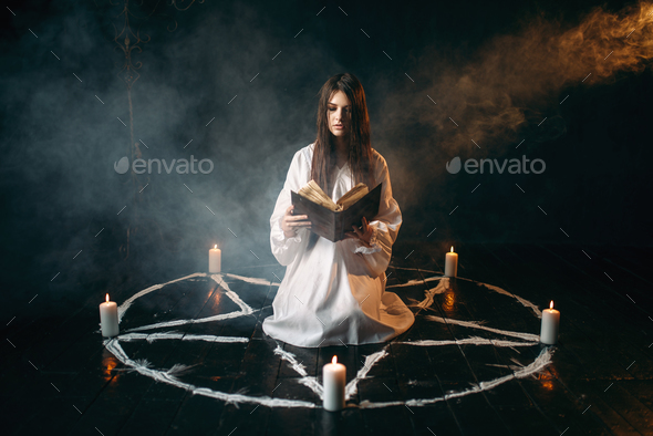 Woman sitting in the center of pentagram circle - Stock Photo - Images