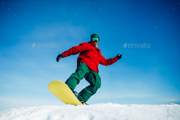 Snowboarder in glasses poses with board in hands - Stock Photo - Images