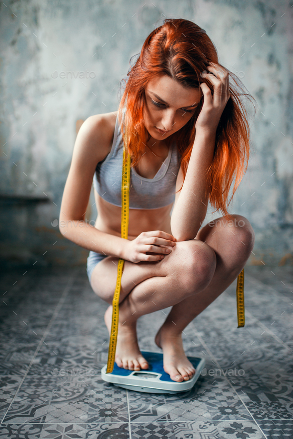 Thin woman in underwear weighed on a scale - Stock Photo - Images