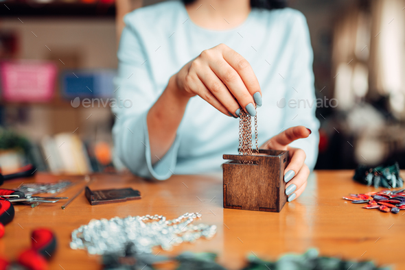 Female hands pulls out metal chain from box - Stock Photo - Images