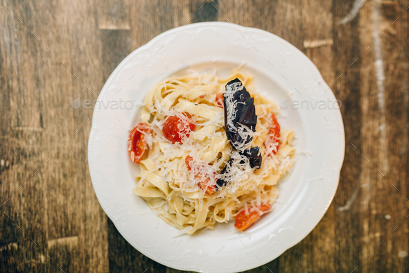 Plate with fresh cooked pasta on wooden table - Stock Photo - Images