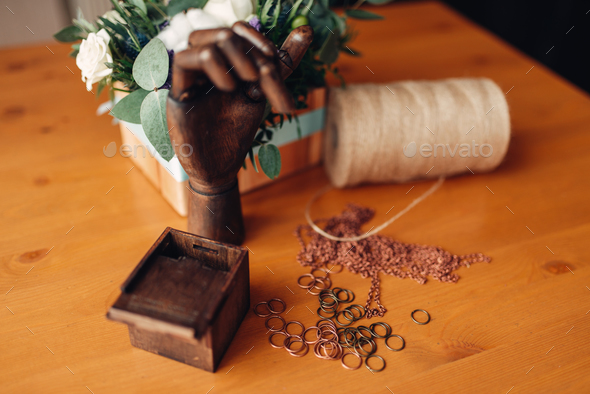 Needlework, metal rings and wooden hand on table - Stock Photo - Images