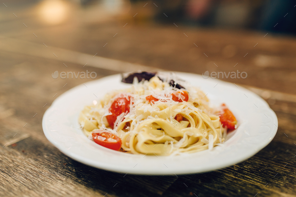 Plate with fresh cooked pasta on wooden table - Stock Photo - Images