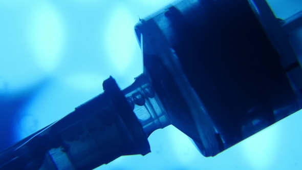 Plastic Syringe Sucks in Water From a Thin Tube in a Blue Medical Laboratory