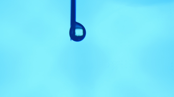 A Bead of Water Grows on a Tip of a Vertical Needle and Comes Down in a Lab. alt