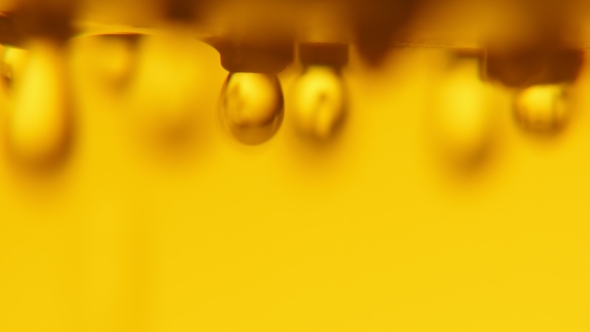 Cheery Drops of Water Dribbling From a Metallic Nozzle in a Golden Bathroom