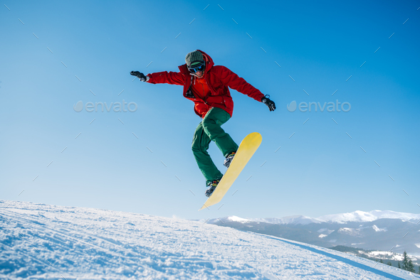 Snowboarder makes a jump on speed slope - Stock Photo - Images