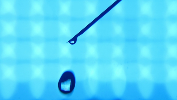 A Bead of Water Grows on a Tip of a Slanting Needle and Falls in a Lab.