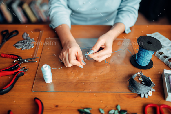 Female hands with pliers, top view, needlework - Stock Photo - Images