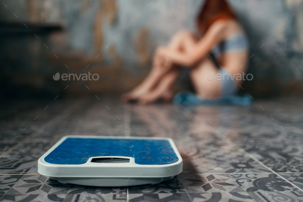Anorexic woman sitting on the floor, weight loss Stock Photo by NomadSoul1