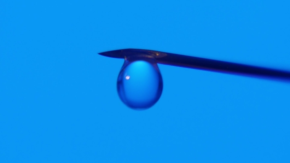 A Drop of Water Gets Bigger on a Tip of a Needle and Falls. A Stream Flows After