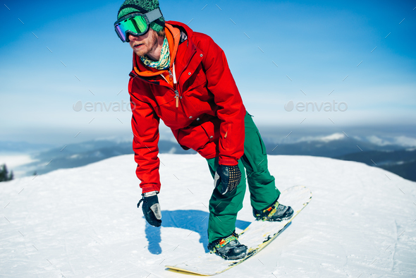 Snowboarder in glasses poses with board in hands - Stock Photo - Images