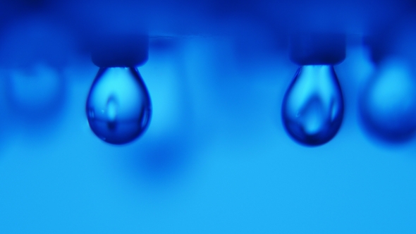 Dazzling Drops of Water Falling From a Metallic Jet in a Modern Blue Bathroom