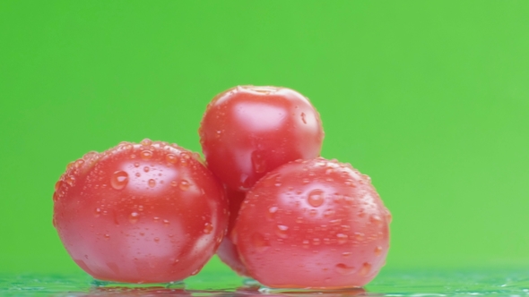 Red Tomato with Water Drops, Slowly Rotating on Green Background, alt