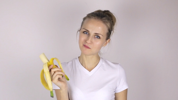 Beautiful Young Woman Eats Banana and Showing Thumb Up.