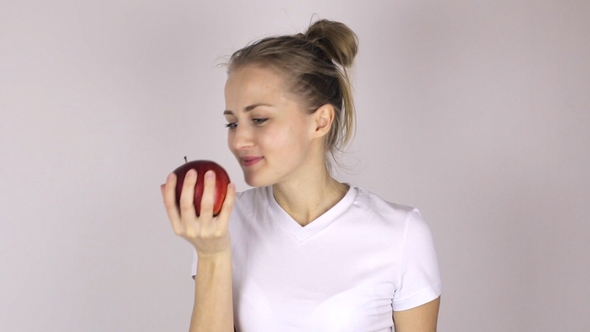 Beautiful Girl Bites a Big and Juicy Red Apple