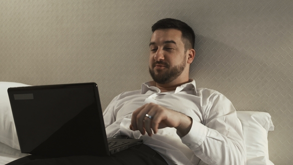 Relaxed Businessman Having Videocall in Hotel Bedroom alt