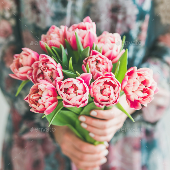 Woman in colorful dress holding bouquet of pink tulips - Stock Photo - Images