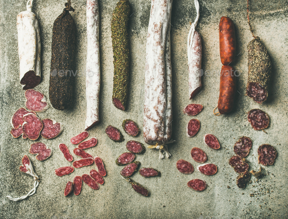 Variety of Spanish or Italian cured sausages cut in slices - Stock Photo - Images