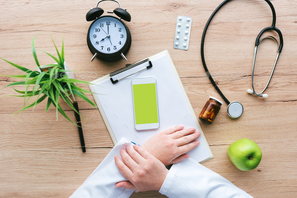 Doctor using smartphone app in hospital office - Stock Photo - Images