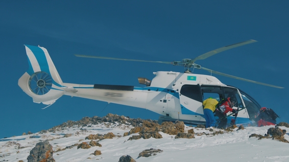 Heliskiing Skiers Are Disembarked From the Helicopter in the Mountains in Winter.  View alt
