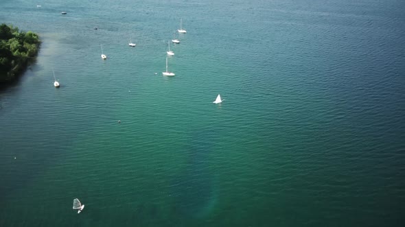 Fly Over Sailboats Anchored in a Bay on a Lake alt