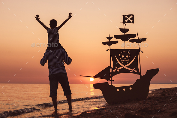 Father and son playing on the beach at the sunset time. - Stock Photo - Images