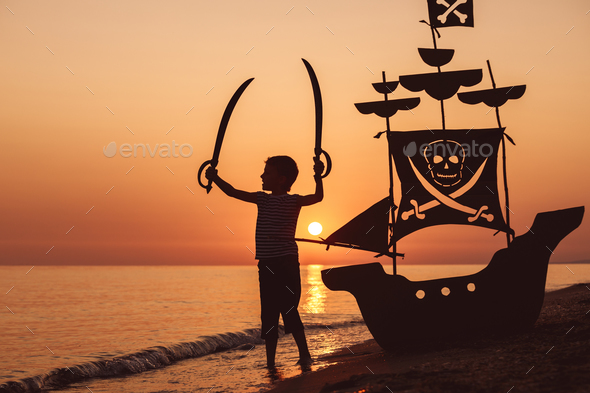One happy little boy playing on the beach at the sunset time. - Stock Photo - Images