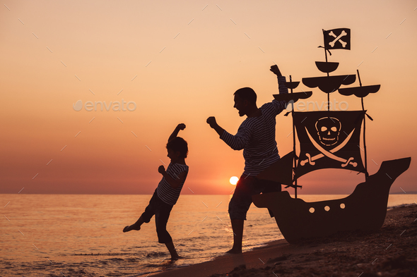 Father and son playing on the beach at the sunset time. - Stock Photo - Images