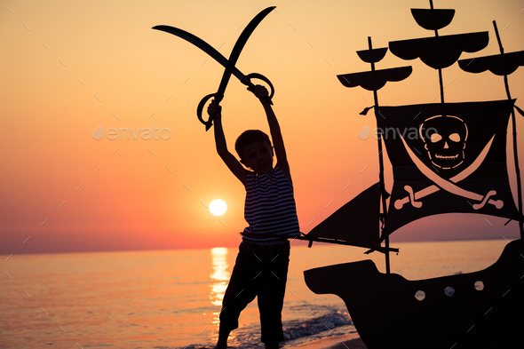 One happy little boy playing on the beach at the sunset time. - Stock Photo - Images