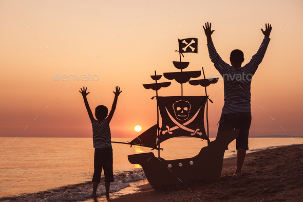 Father and son playing on the beach at the sunset time. - Stock Photo - Images